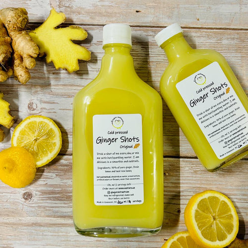 TWO BOTTLES OF FRESH GINGER HONEY LEMON SHOTS WITH FRESH PIECES OF GINGER AND LEMON